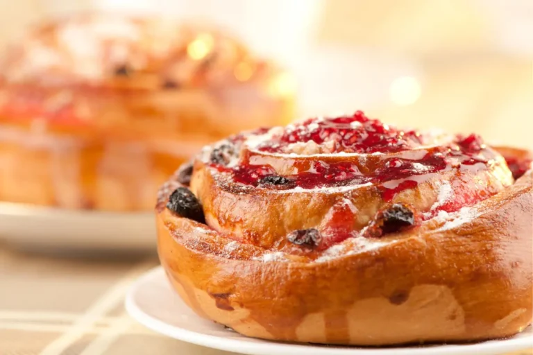 Soft strawberry cheesecake cinnamon rolls topped with cream cheese frosting.